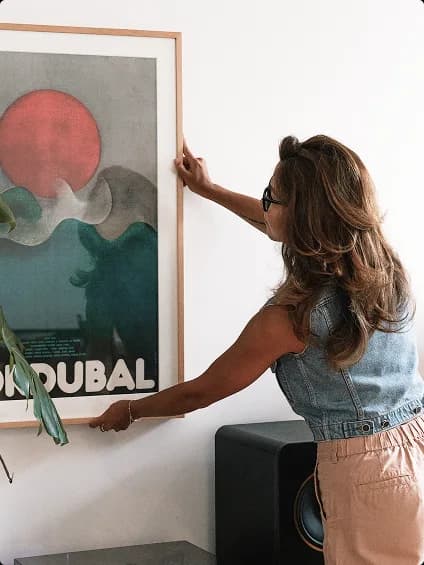Collector hanging artwork on a wall