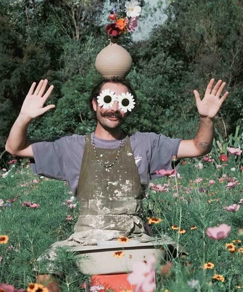 Jamie Smith of Kiln Studio in a flower field wearing daisy sunglasses